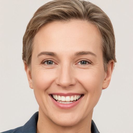 Joyful white young-adult female with short  brown hair and grey eyes