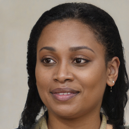 Joyful black young-adult female with long  brown hair and brown eyes
