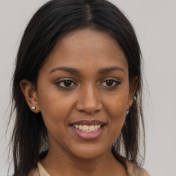 Joyful black young-adult female with long  brown hair and brown eyes