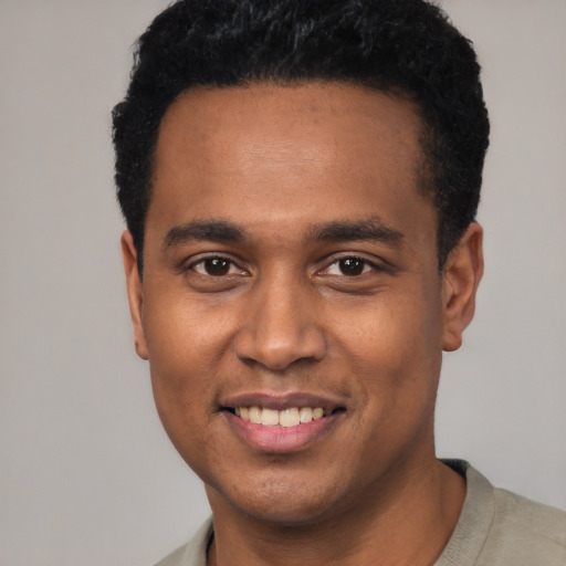 Joyful black young-adult male with short  black hair and brown eyes