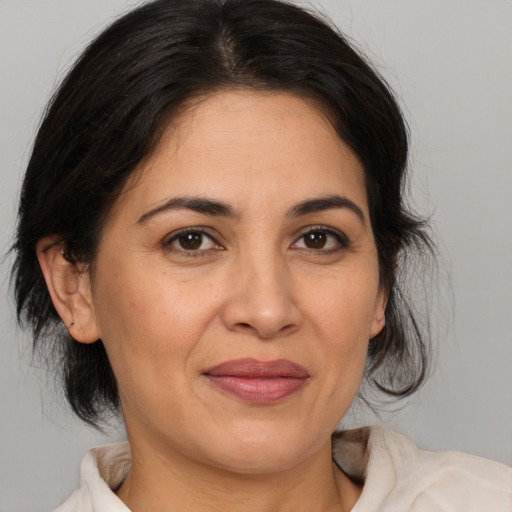 Joyful latino adult female with medium  brown hair and brown eyes