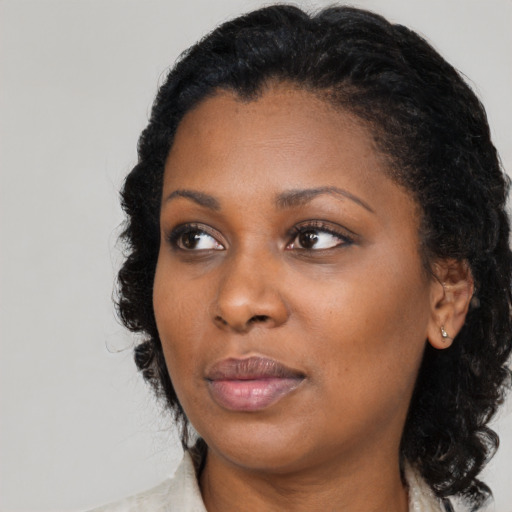 Joyful black young-adult female with medium  black hair and brown eyes