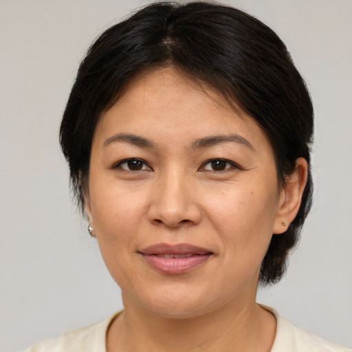 Joyful asian adult female with medium  brown hair and brown eyes