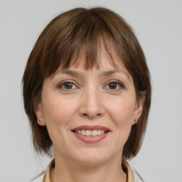 Joyful white adult female with medium  brown hair and grey eyes