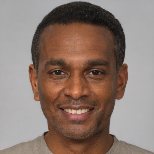 Joyful black young-adult male with short  black hair and brown eyes