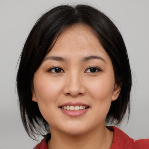 Joyful asian young-adult female with medium  brown hair and brown eyes