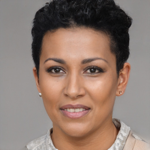 Joyful black young-adult female with short  black hair and brown eyes