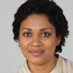 Joyful black young-adult female with long  brown hair and brown eyes