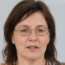 Joyful white adult female with long  brown hair and blue eyes