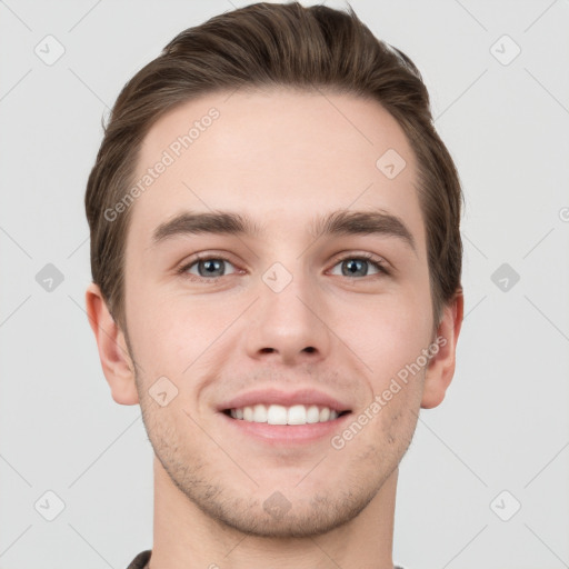 Joyful white young-adult male with short  brown hair and grey eyes