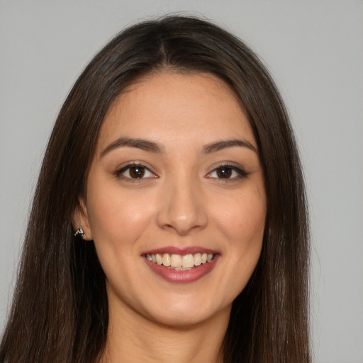 Joyful white young-adult female with long  brown hair and brown eyes