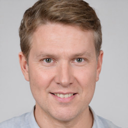 Joyful white adult male with short  brown hair and grey eyes