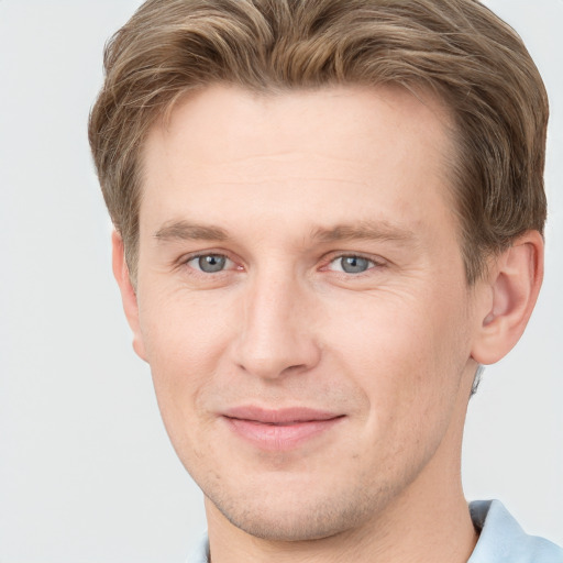 Joyful white young-adult male with short  brown hair and grey eyes