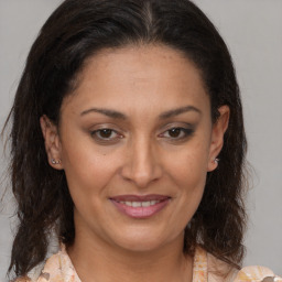 Joyful latino adult female with medium  brown hair and brown eyes