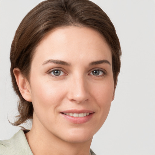 Joyful white young-adult female with medium  brown hair and grey eyes