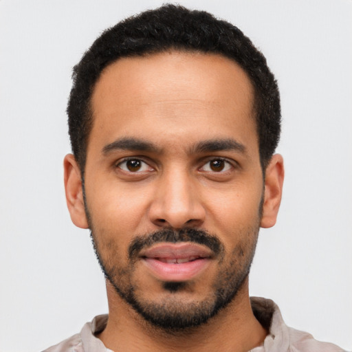 Joyful latino young-adult male with short  black hair and brown eyes