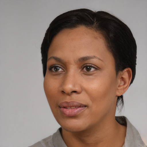 Joyful black young-adult female with short  black hair and brown eyes