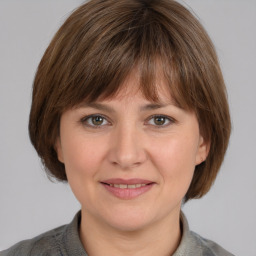 Joyful white adult female with medium  brown hair and grey eyes