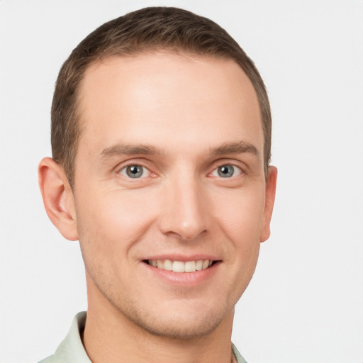 Joyful white young-adult male with short  brown hair and grey eyes