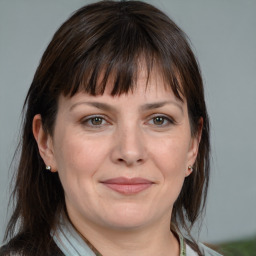 Joyful white adult female with medium  brown hair and grey eyes