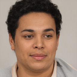 Joyful latino young-adult male with short  brown hair and brown eyes