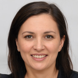 Joyful white adult female with long  brown hair and brown eyes