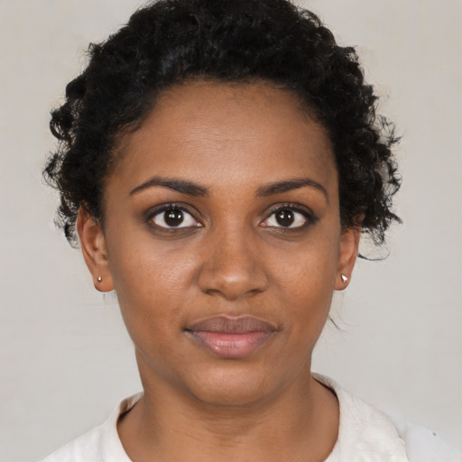 Joyful black young-adult female with short  black hair and brown eyes