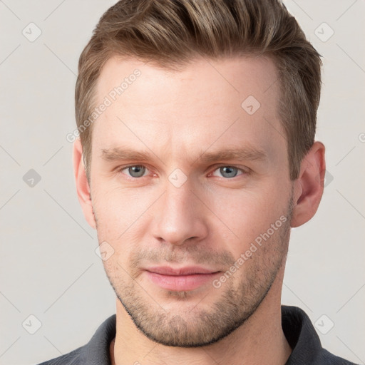 Joyful white young-adult male with short  brown hair and grey eyes