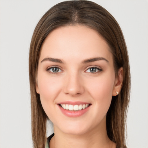 Joyful white young-adult female with long  brown hair and green eyes