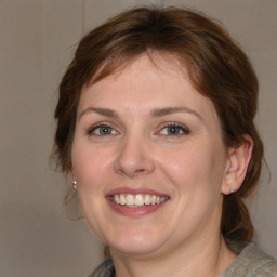 Joyful white young-adult female with medium  brown hair and grey eyes