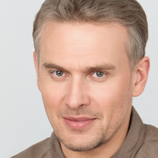 Joyful white adult male with short  brown hair and brown eyes