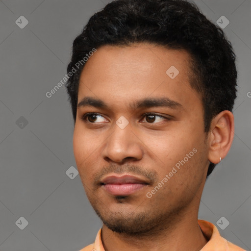 Joyful latino young-adult male with short  black hair and brown eyes