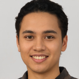 Joyful latino young-adult male with short  brown hair and brown eyes