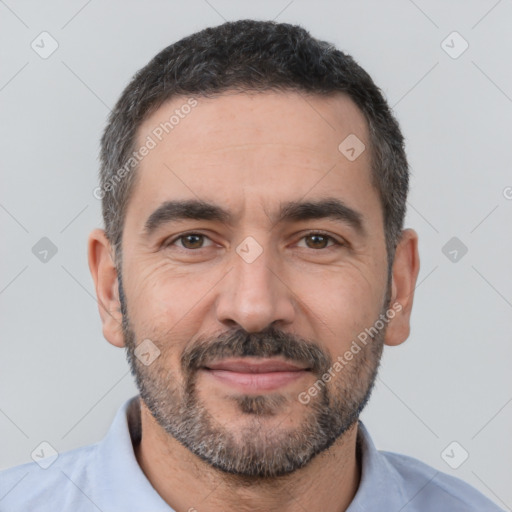 Joyful white adult male with short  black hair and brown eyes