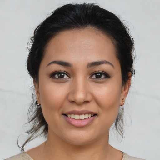 Joyful latino young-adult female with medium  brown hair and brown eyes