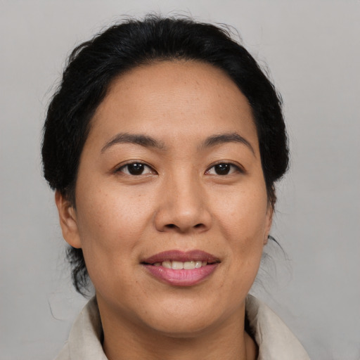 Joyful asian adult female with medium  brown hair and brown eyes
