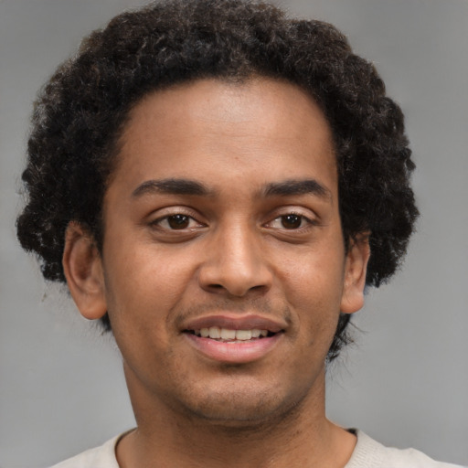 Joyful black young-adult male with short  brown hair and brown eyes