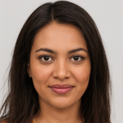 Joyful latino young-adult female with long  brown hair and brown eyes