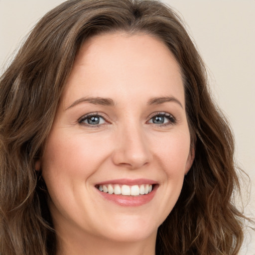 Joyful white young-adult female with long  brown hair and green eyes