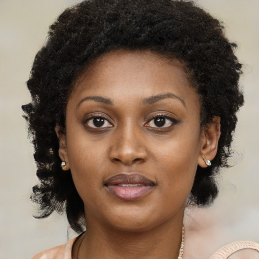 Joyful black young-adult female with long  brown hair and brown eyes