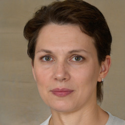 Joyful white adult female with medium  brown hair and grey eyes