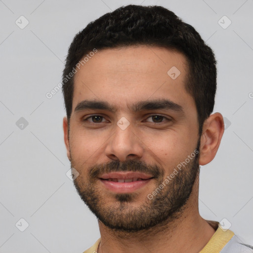 Joyful white young-adult male with short  black hair and brown eyes