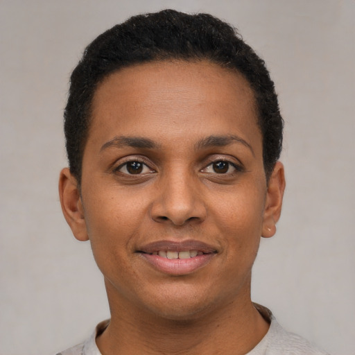 Joyful black young-adult female with short  black hair and brown eyes