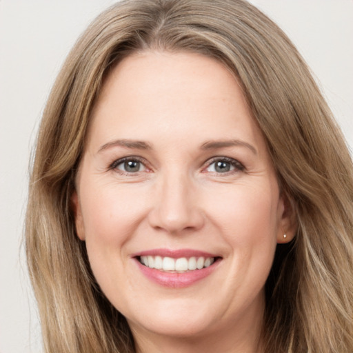 Joyful white young-adult female with long  brown hair and green eyes