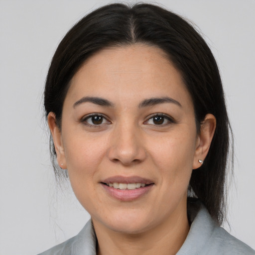 Joyful latino young-adult female with medium  brown hair and brown eyes