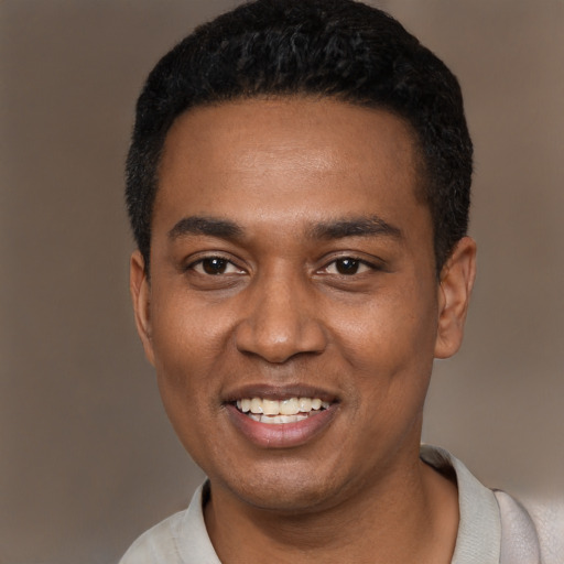 Joyful black young-adult male with short  black hair and brown eyes