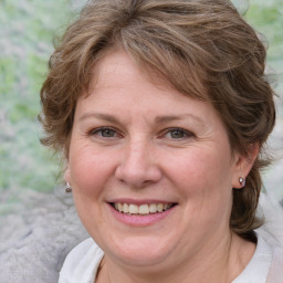 Joyful white adult female with medium  brown hair and blue eyes