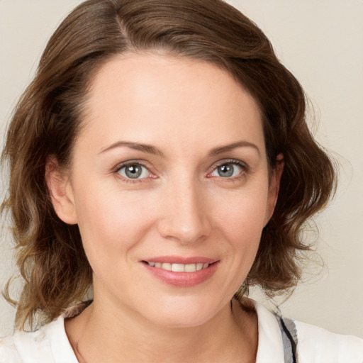 Joyful white young-adult female with medium  brown hair and blue eyes