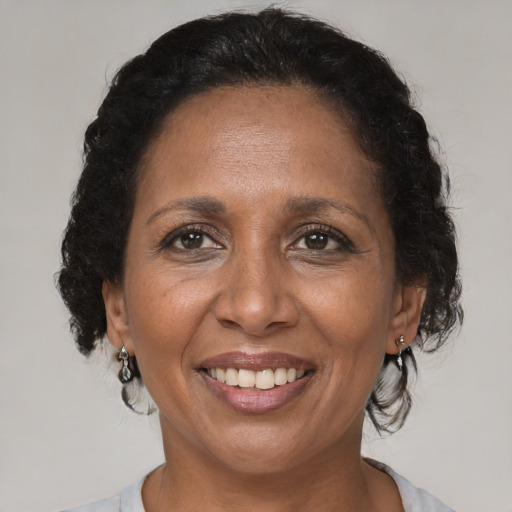 Joyful black adult female with medium  brown hair and brown eyes