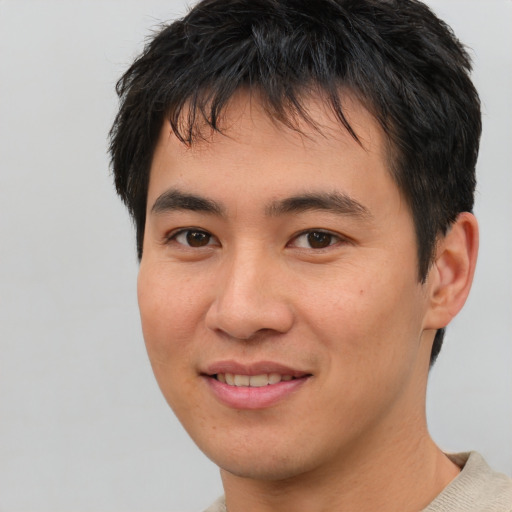 Joyful asian young-adult male with short  brown hair and brown eyes